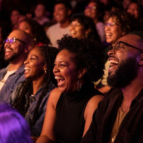 Three people in the front row laughing at a show