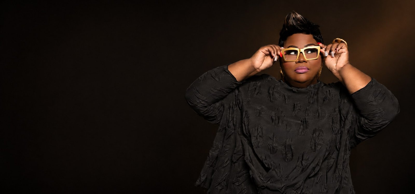 Comedienne Tanya Lewis lowering her glasses